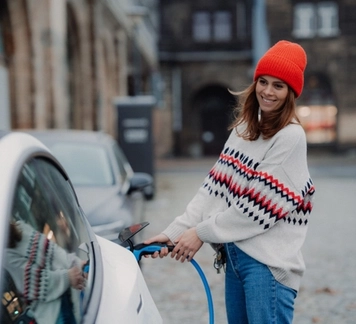 Istock: bilde av ung dame som setter ladeplugg i bilen